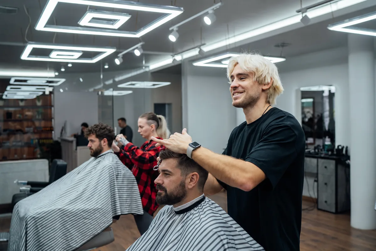 Несколько мастеров барбершопа «Соул» одновременно работают с клиентами в занятом зале