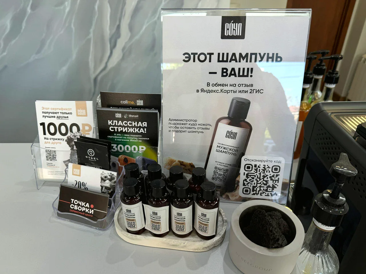 Шампуни и карточка с предложением подарка за отзыв в предкассовой зоне барбершопа «Соул»